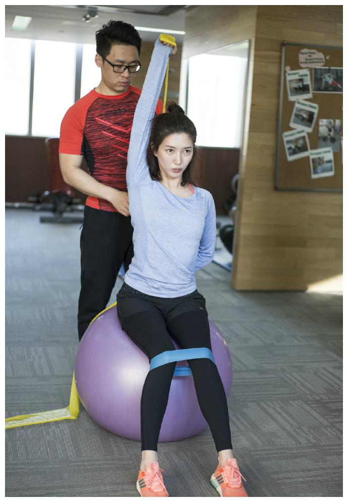 更是结合了瑜伽球和弹力带等一系列运动器材,健身教练在一旁指导动作