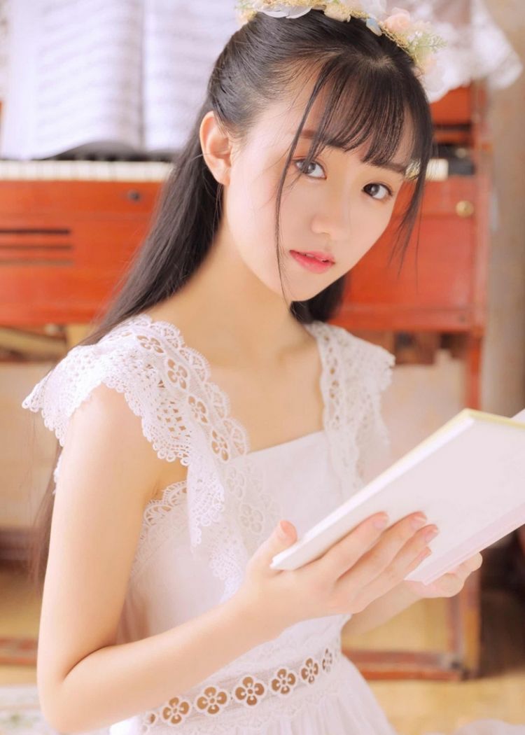 清纯美女长的水灵灵的,漂亮极了,看她身穿白色连衣裙头戴花环