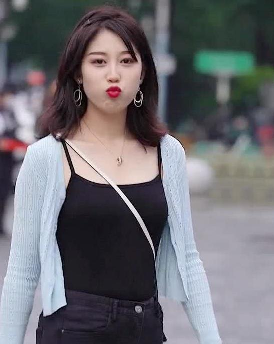 街拍:小姐姐身穿黑色t恤搭黑色牛仔裤,嘴巴嘟嘟尽显可爱