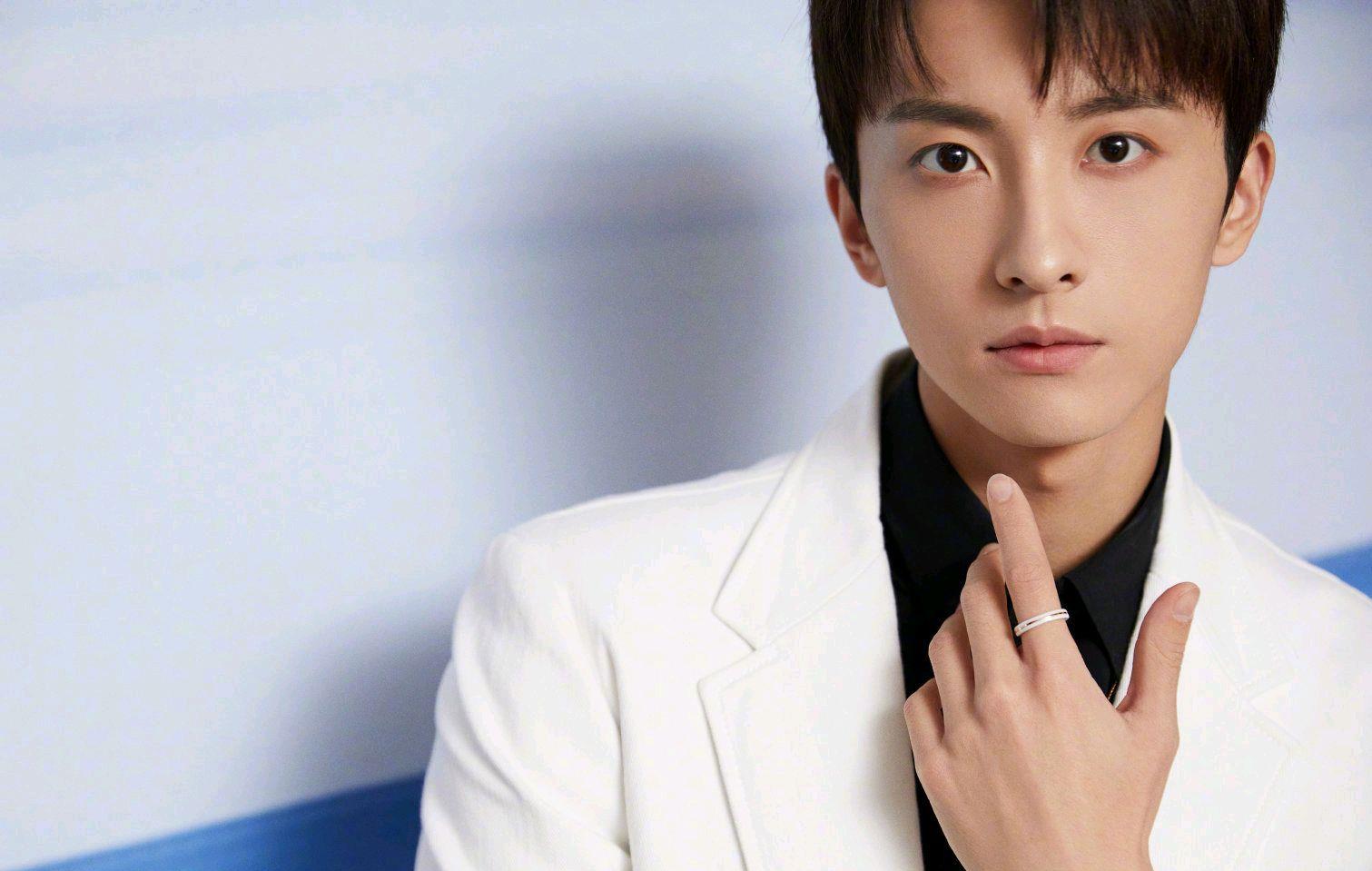 牛骏峰身着白色西装外套搭黑色衬衫出席活动,经典黑白