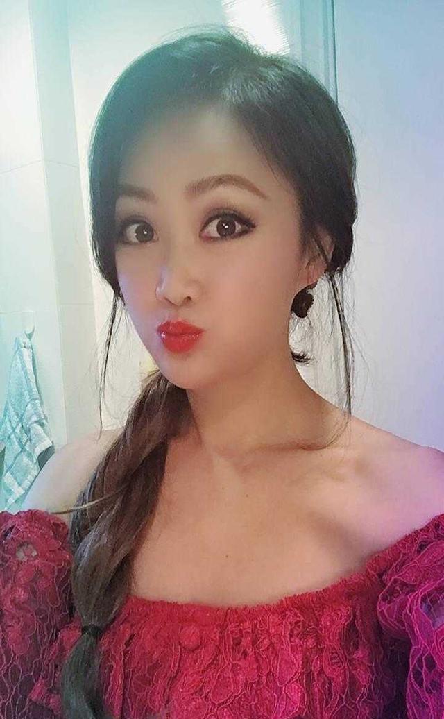 梁小冰哪像50岁了?穿红色一字肩衣嘟嘴自拍,太浓妆美得认不出