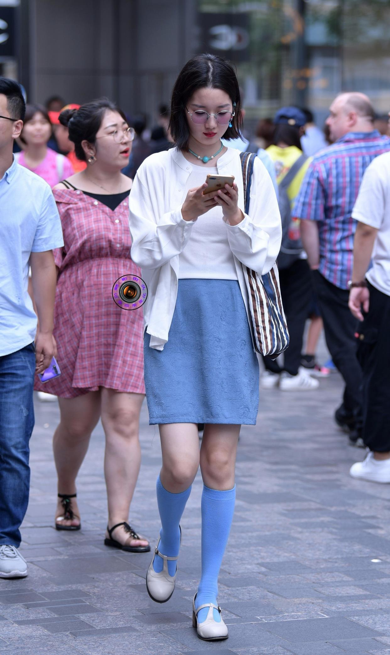 秋天,美女用蓝色长筒袜搭配蓝色半身裙,表达自己的审美眼光