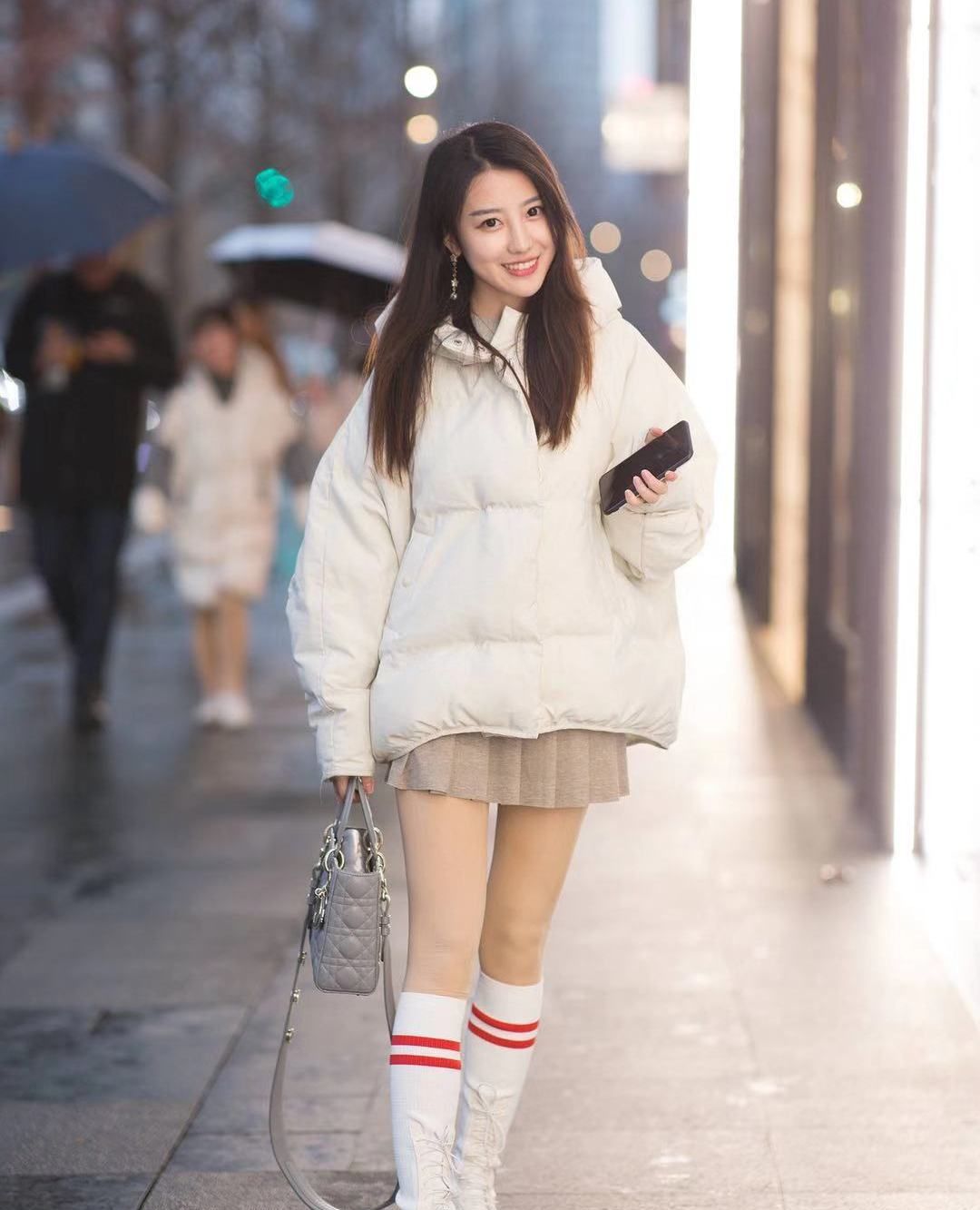 街拍:小姐姐白色宽松羽绒服搭配百褶裙,身材高挑长腿吸睛_高清图集