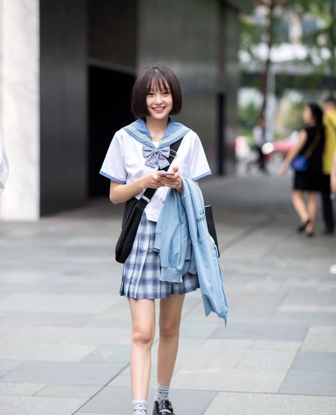 街拍:小姐姐白色上衣搭配格纹短裙,短发清纯笑容甜美动人