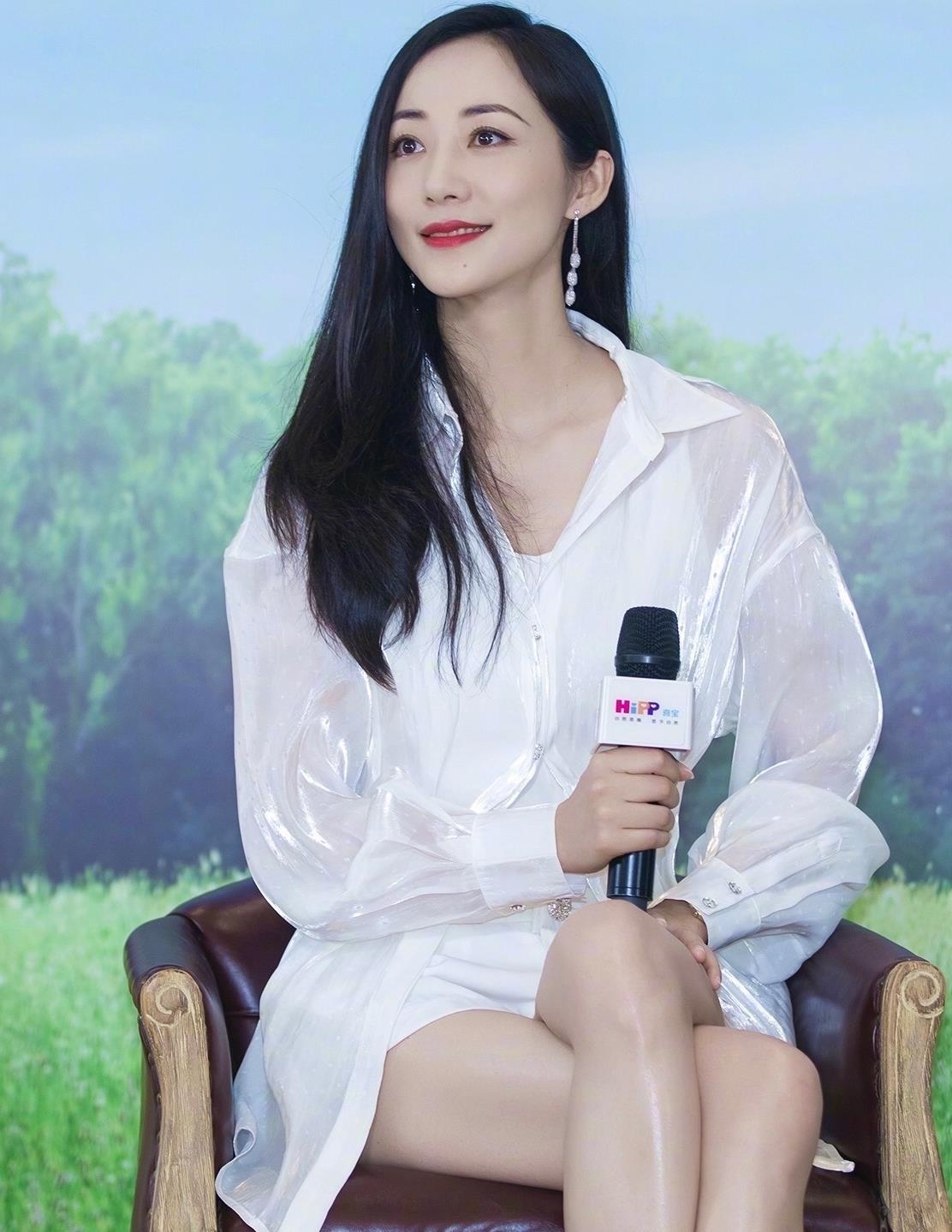 最近韩雪出席活动,身穿白色长款衬衫,这款衬衫的面料采用亮丝的设计