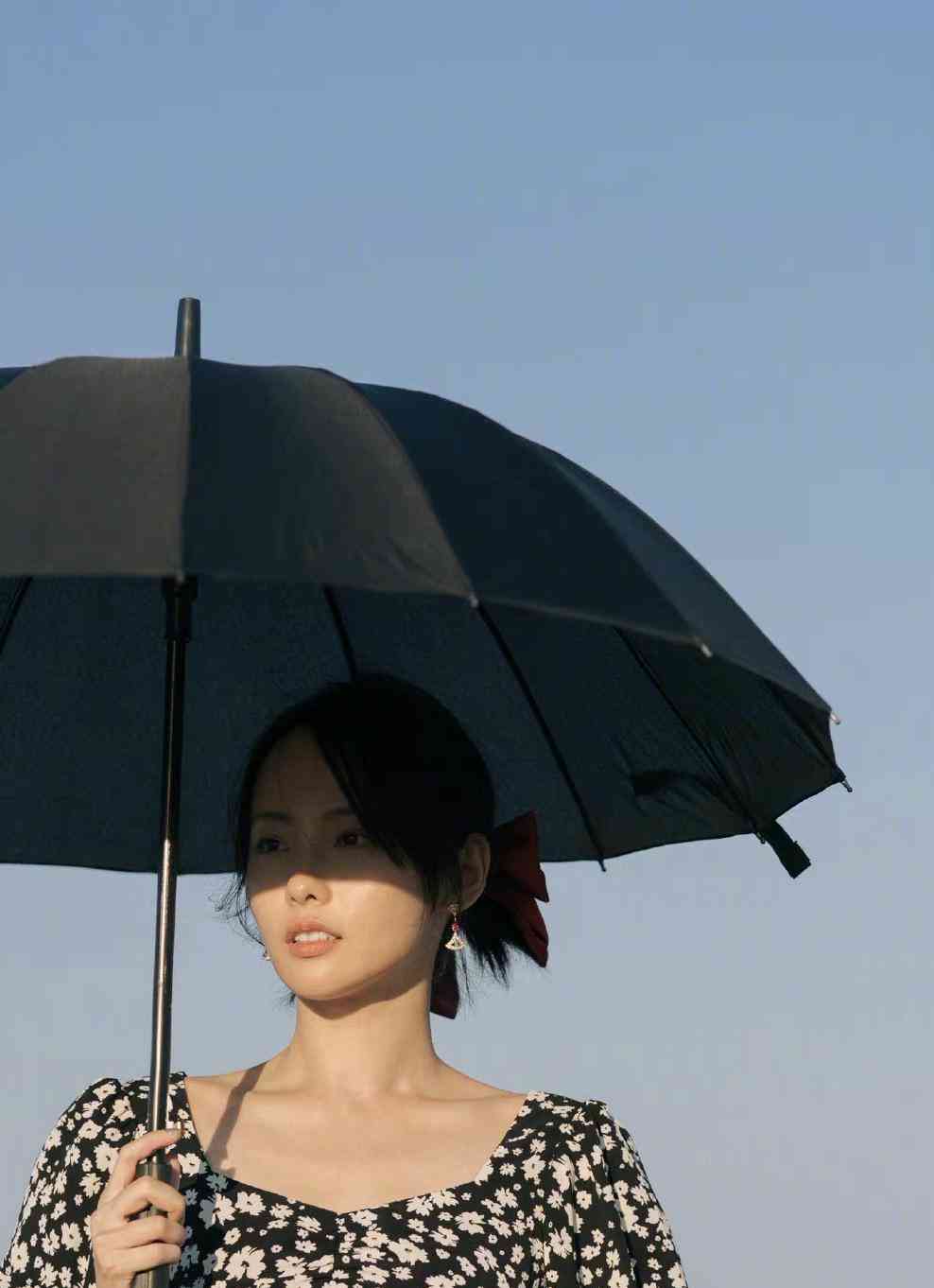 张嘉倪撑伞海边漫步,一袭黑色碎花连衣裙漫步海边,总觉得不搭