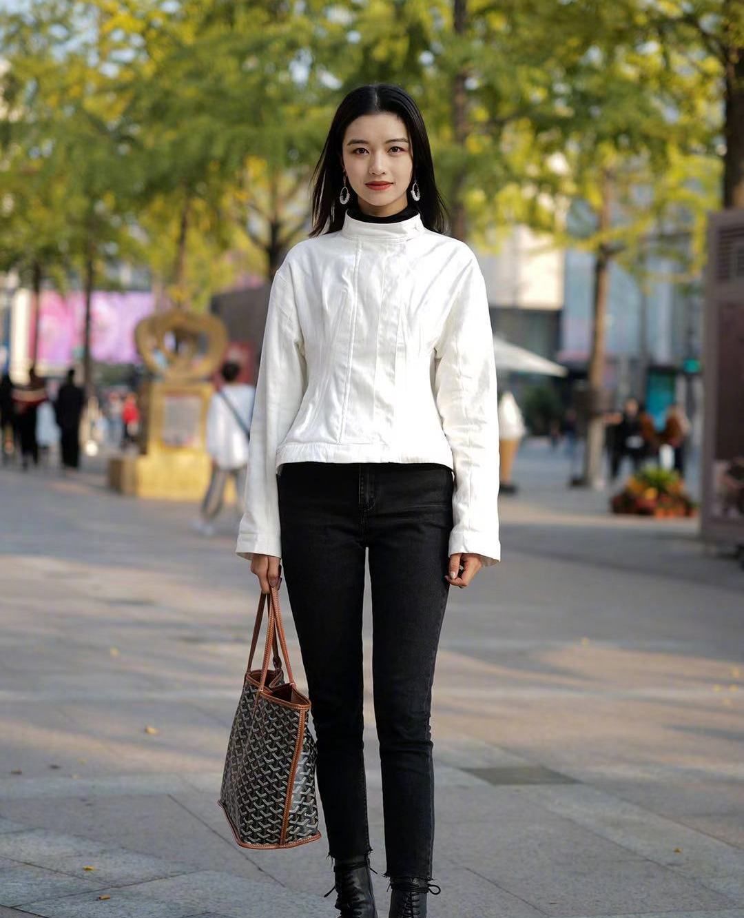 街拍:小姐姐白色上衣搭配黑色紧身裤,长发披肩笑容甜美