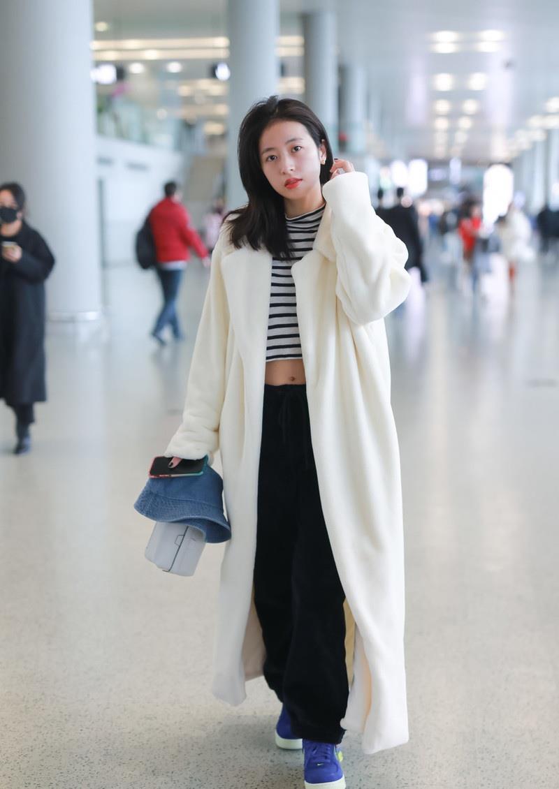 周雨彤穿羊羔毛大衣走机场,露脐装个性十足,嘟嘴卖萌真可爱