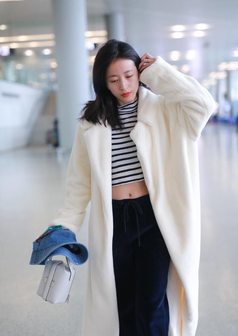 深沉的颜色,特别有个性,如果不看外套,单看里面的装扮,周雨彤好像一位