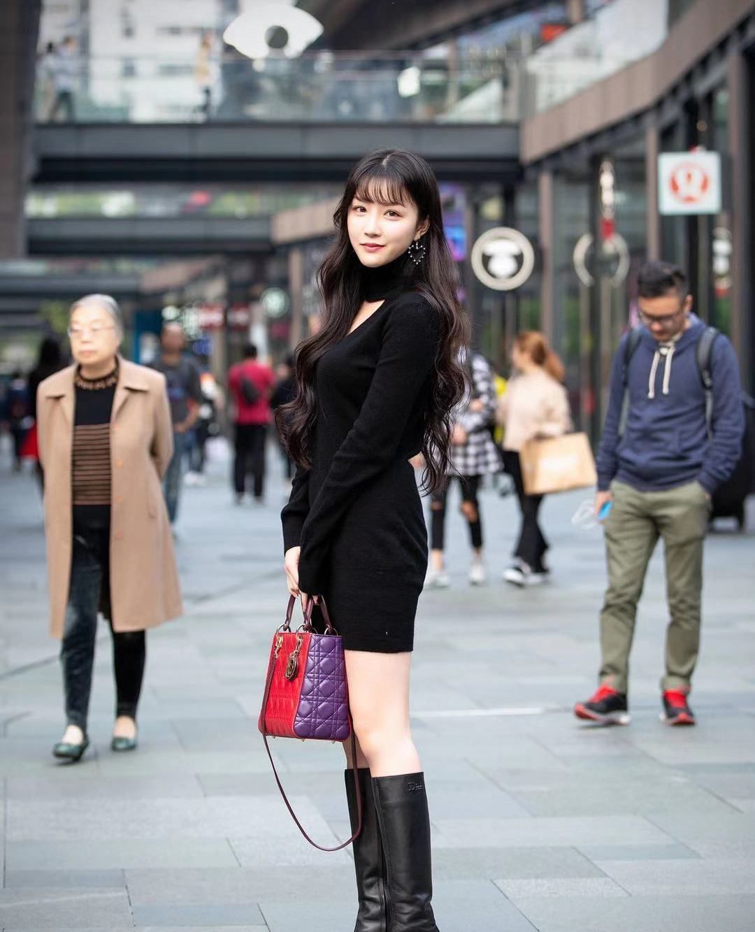 街拍:小姐姐黑色紧身短裙搭配同色长筒皮靴,笑容甜美动人