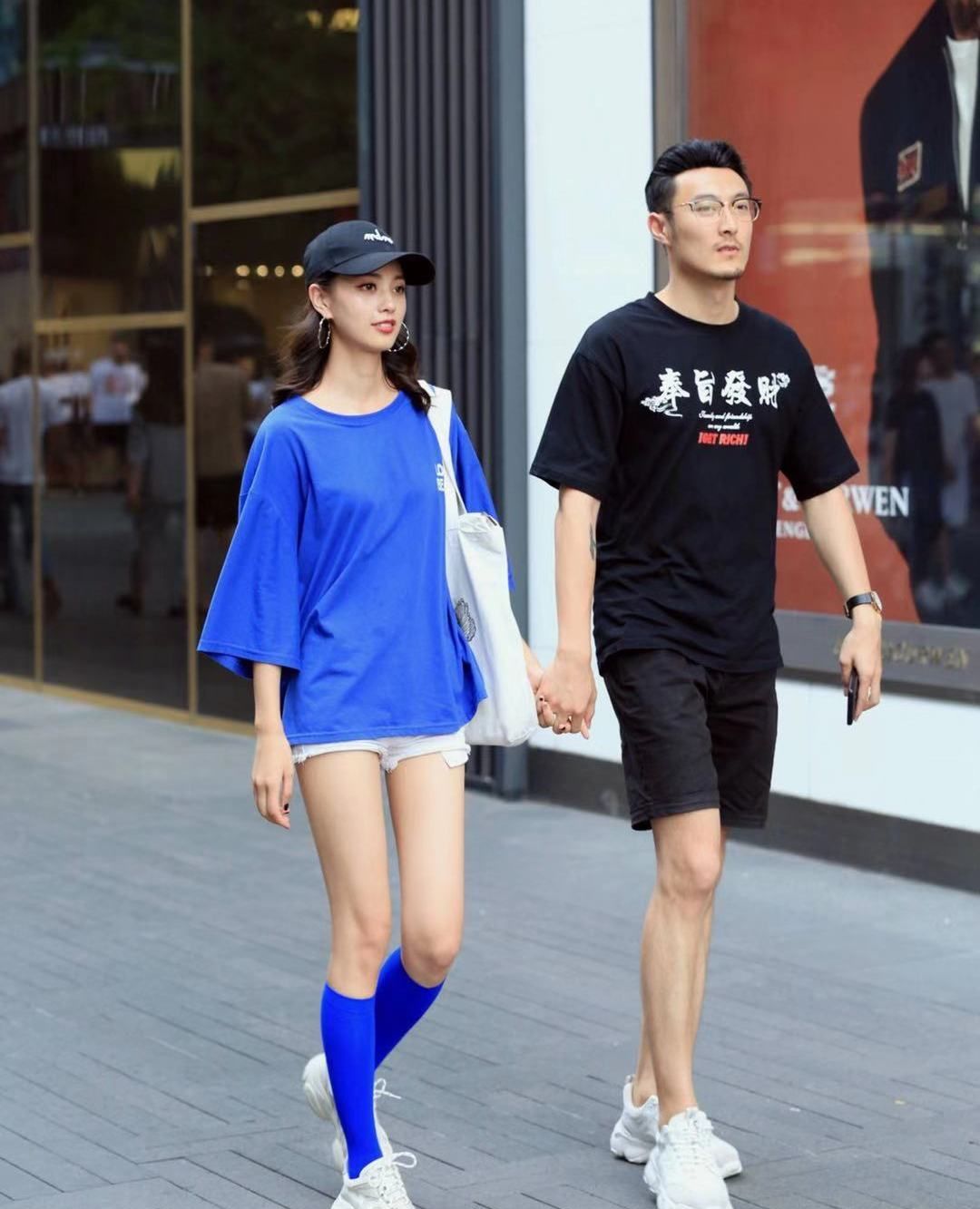 街拍,小姐姐蓝色宽松短袖搭配白色短裤,头戴棒球帽休闲时尚