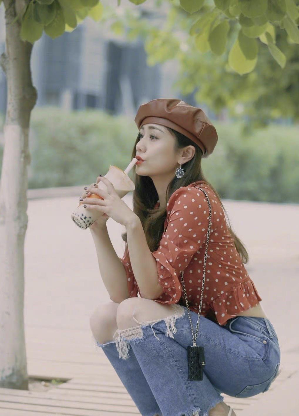 刘芸清爽写真波点雪纺上衣配破洞牛仔裤蹲地上喝奶茶俏皮可爱