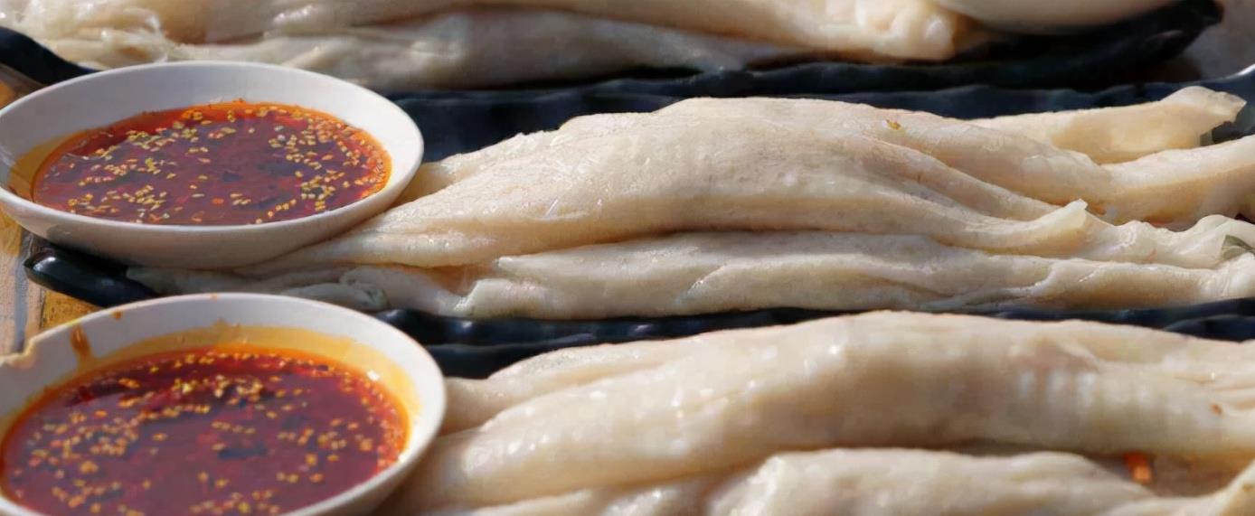 子长煎饼是陕西省延安市子长县著名的传统小吃,饼薄如纸,银白透亮