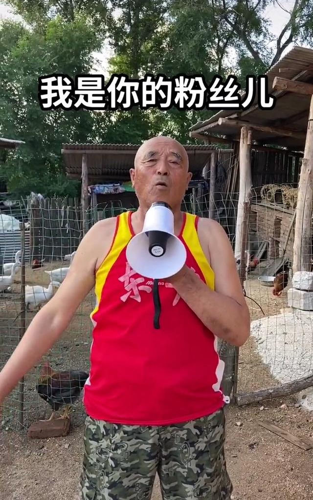 视频中,他是一个光头爷爷,门牙崩了两颗,身穿红色背心,下身搭配一条