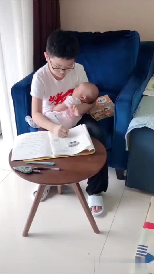 做好饭出来哥哥抱着睡着的妹妹写作业这就是所谓的兄妹情深吧
