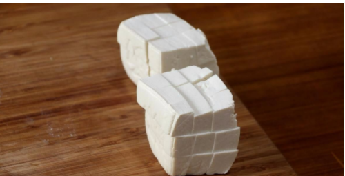 锅内倒水,加入一小勺的盐,将水烧开,随后把切好的豆腐块儿倒入水中,煮