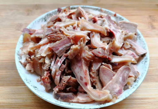 3,锅内加水烧开,把羊头肉倒入锅,加入1勺料酒,几片生姜在锅内煮上几