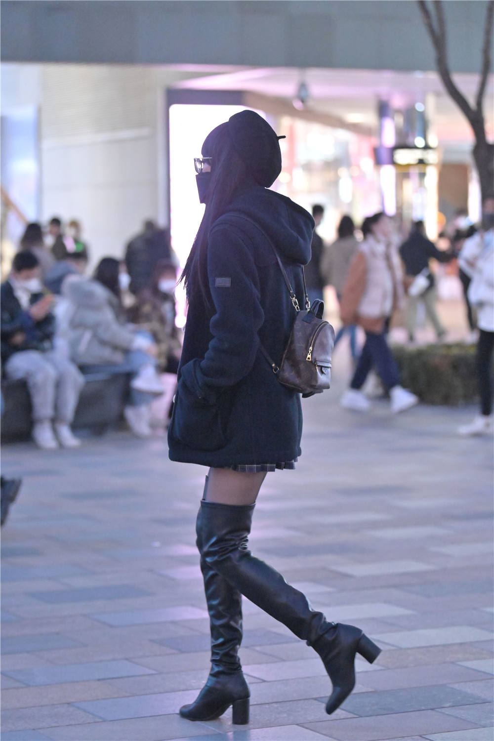 也适合冬季出门,这位美女选择黑色为主的搭配,一双黑色皮质过膝长靴