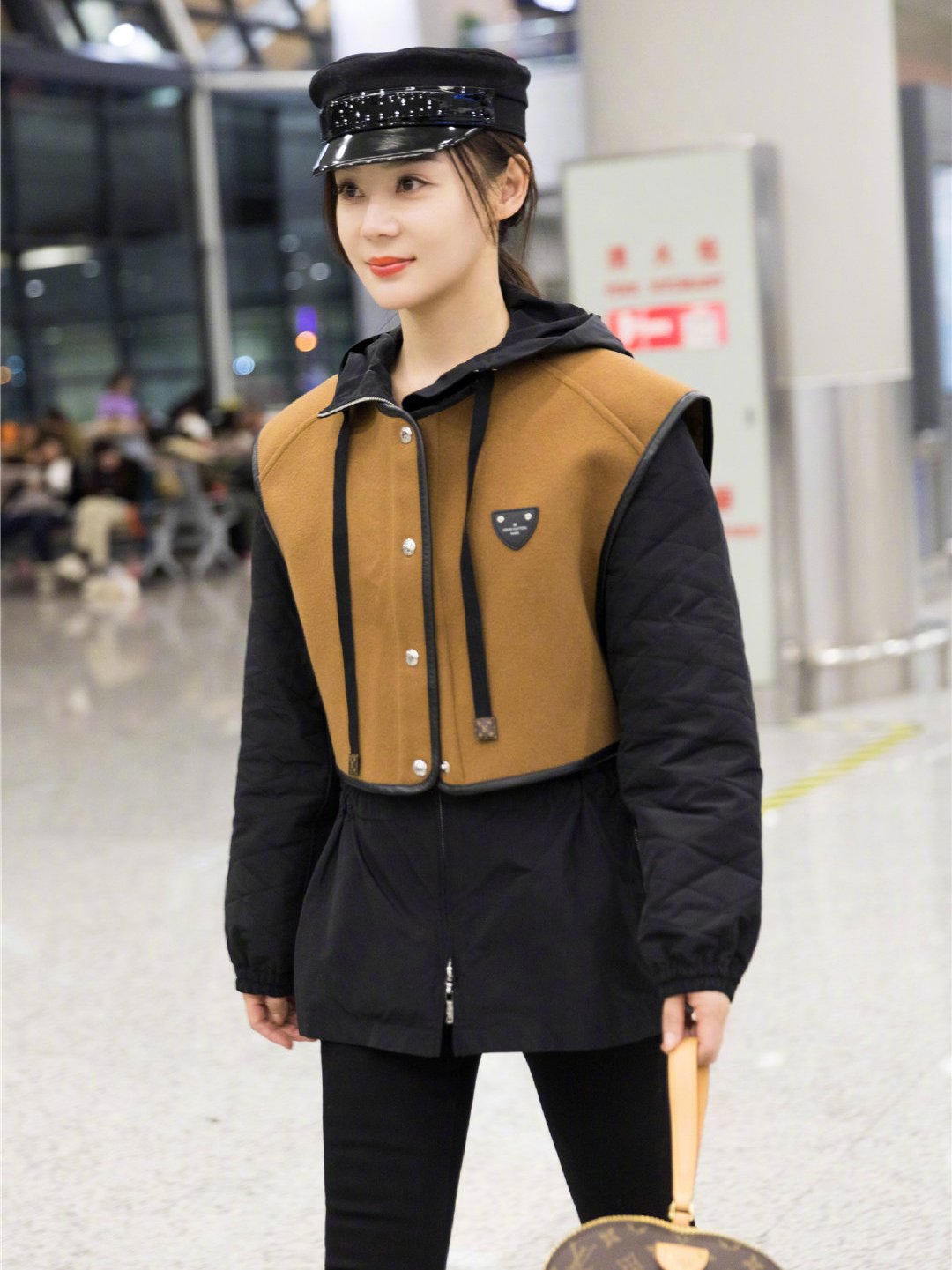 袁姗姗现身机场拼接大衣搭配报童帽手提包抢镜