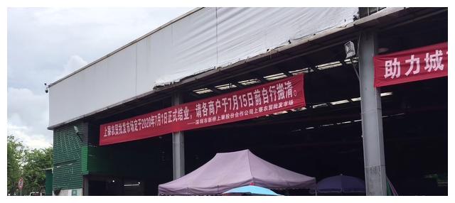 的挡板已经围了起来,里面已经是之让出不让进,在上寮菜市场挂着横幅