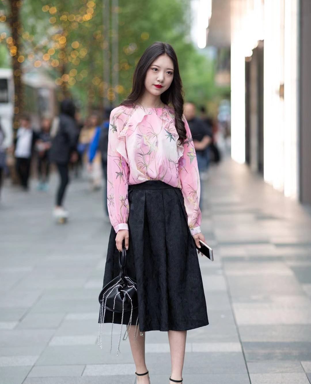 街拍:小姐姐粉色印花上衣搭配黑色半身裙,长发披肩甜美优雅