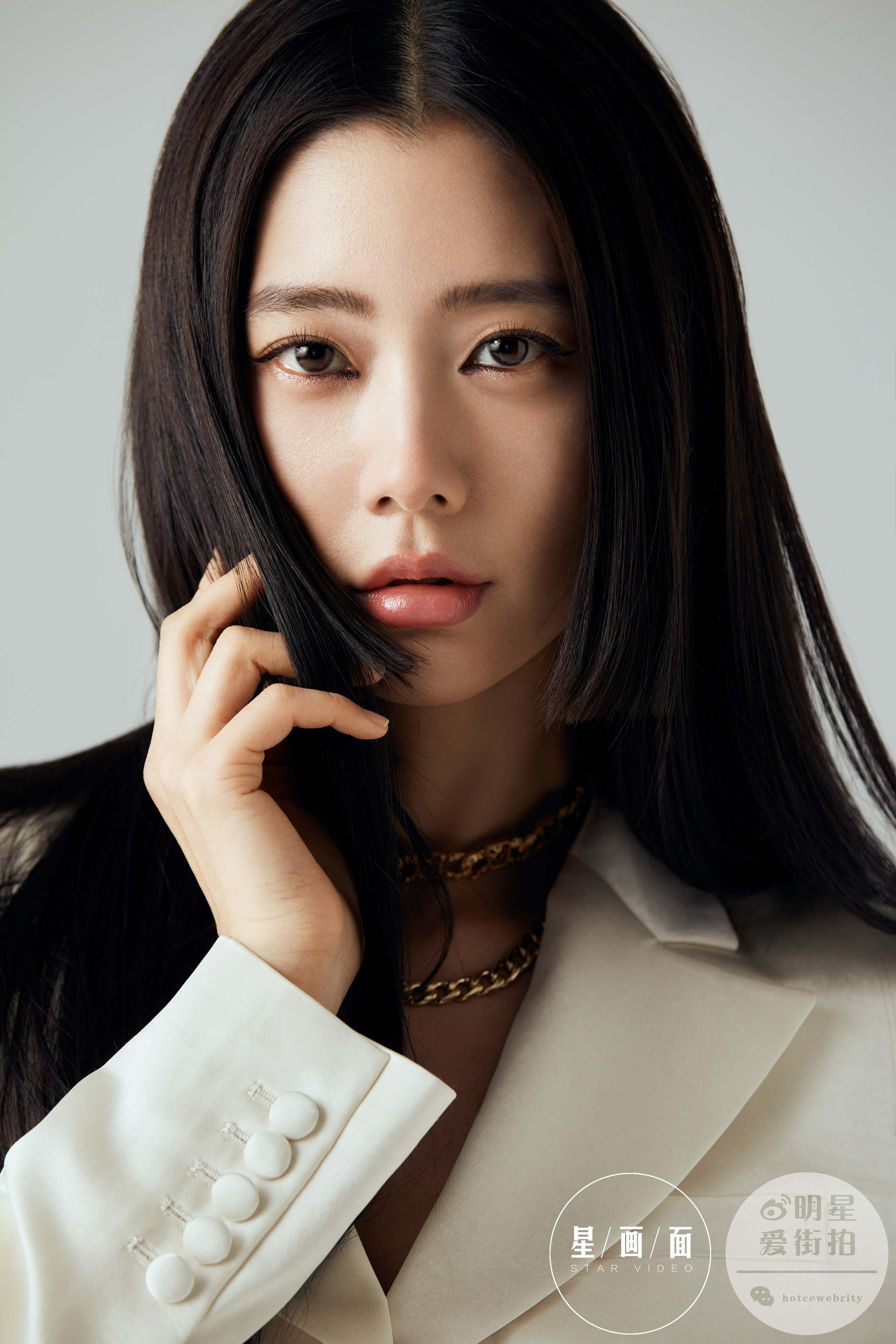 照片中,克拉拉身着白色礼服裙,夸张的袖子让整体造型更有亮点,长发束