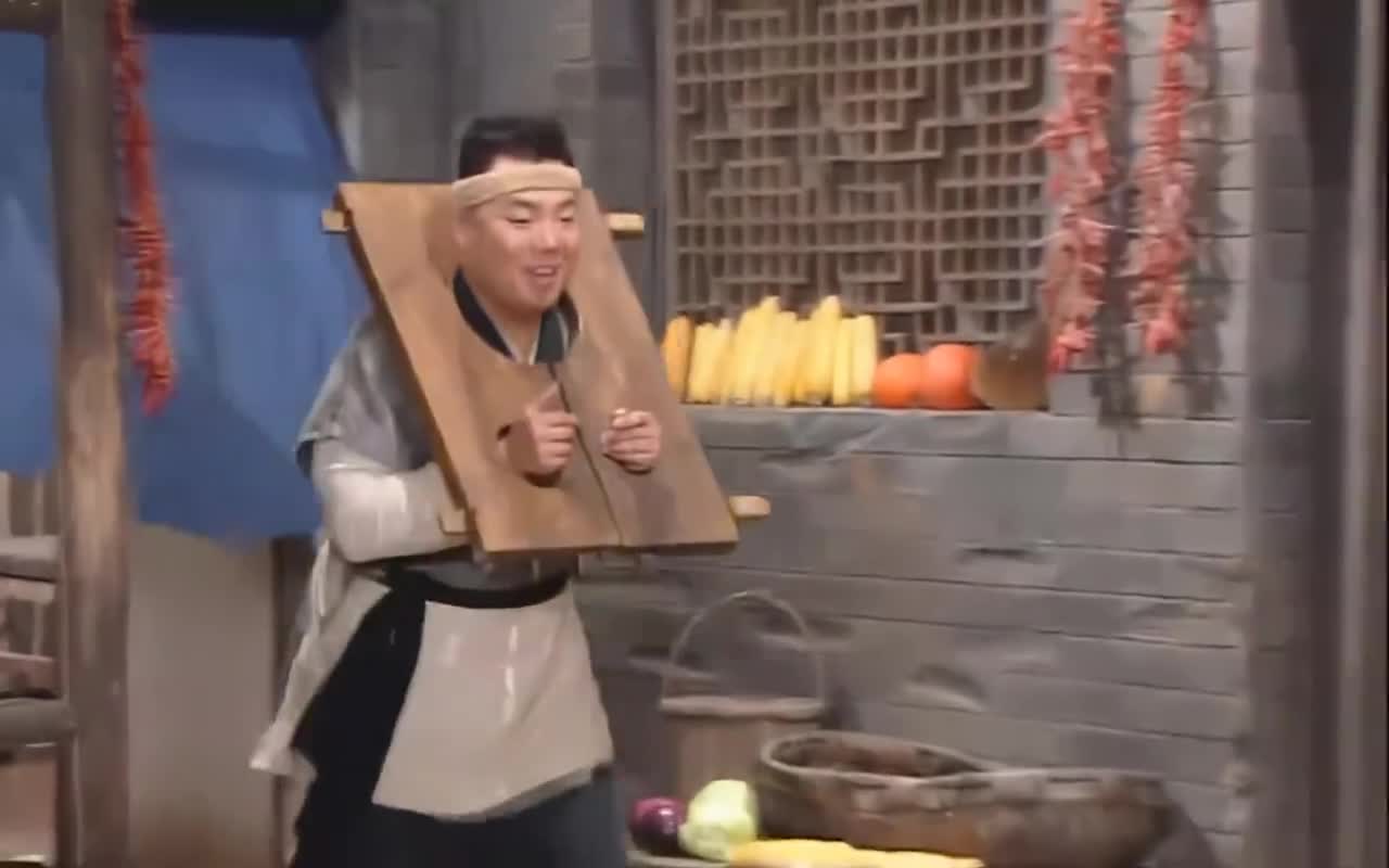 李大嘴戴着枷锁,想让白展堂给他开锁,白展堂却不帮他