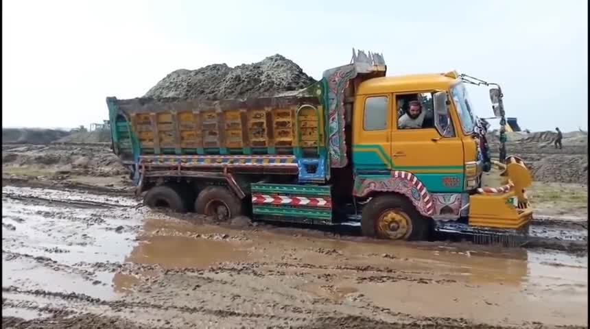 v8引擎的卡车满载泥沙过泥潭,轮胎都陷进去了
