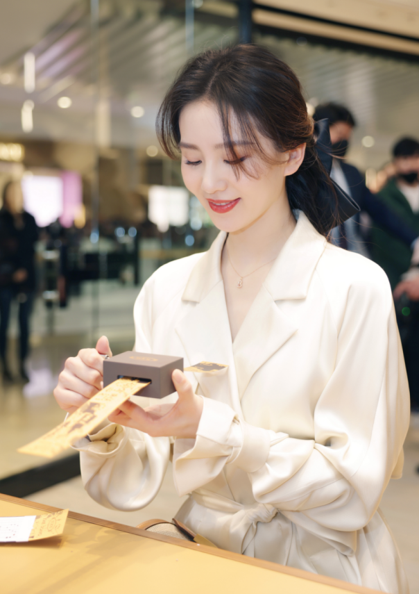 活动当天,刘诗诗身穿白色长款大衣,搭配同色系链条饰扣高跟鞋与编织款