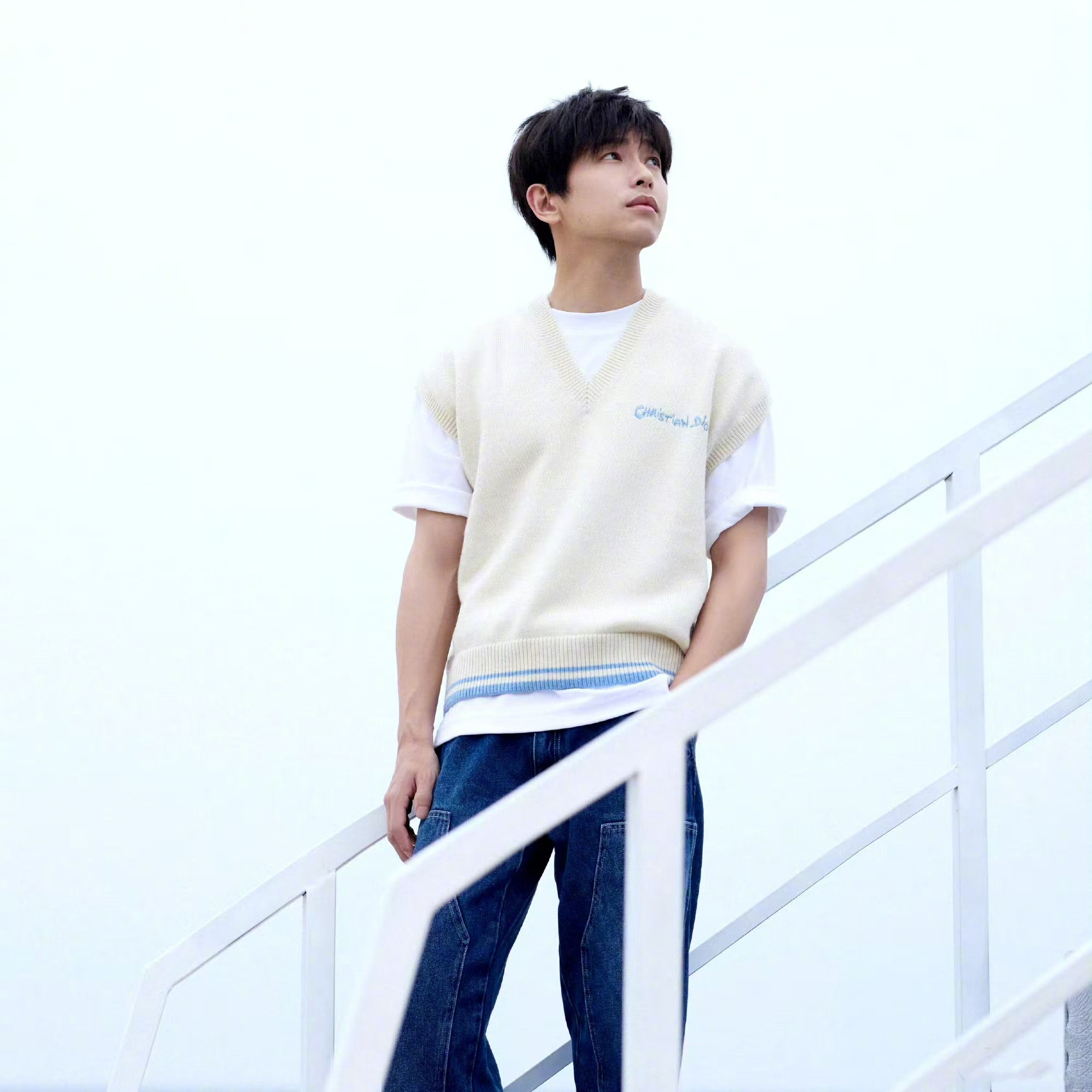 彭昱畅身穿白色毛衣马甲,以蓝天大海为背景,扑面而来的清爽气息