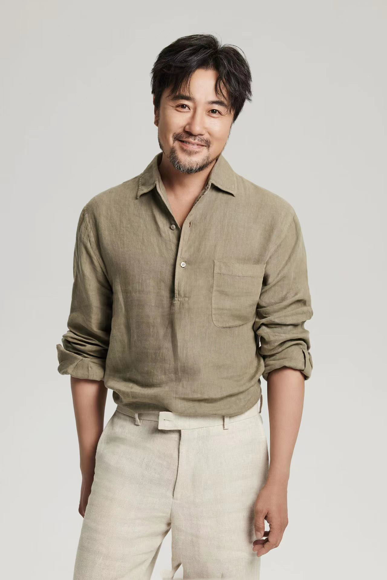 赵阳身着亚麻绿色衬衫搭配同质地米色亚麻休闲裤目光温暖