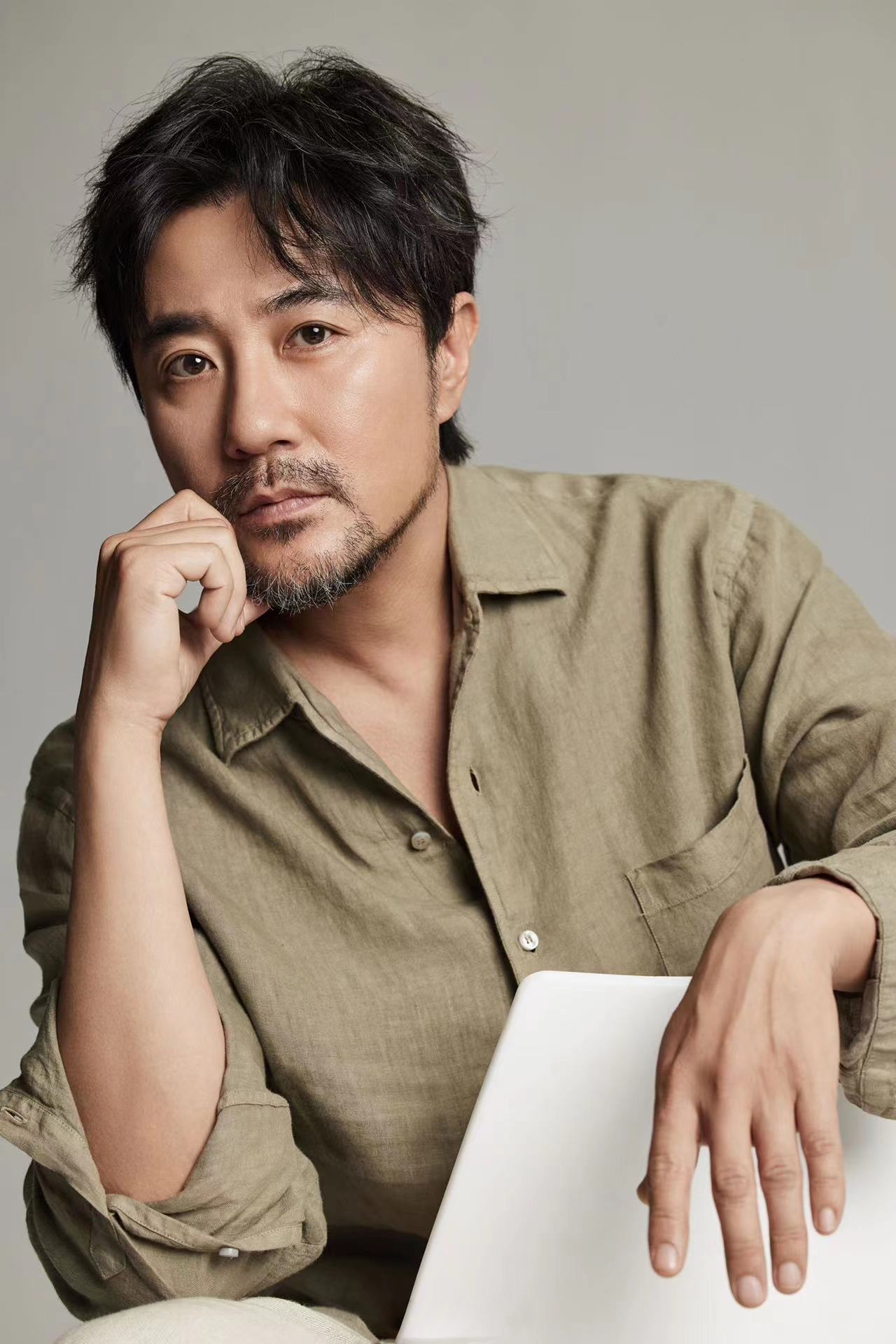 赵阳身着亚麻绿色衬衫搭配同质地米色亚麻休闲裤目光温暖