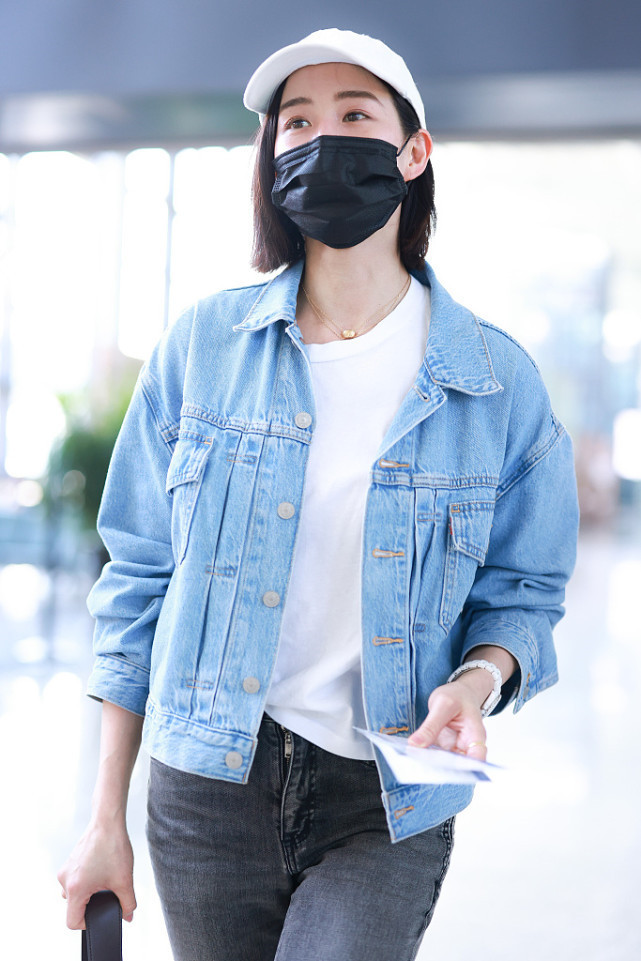 我们看张钧甯戴着一顶白色的帽子,戴着一个口罩,看起来显得很低调