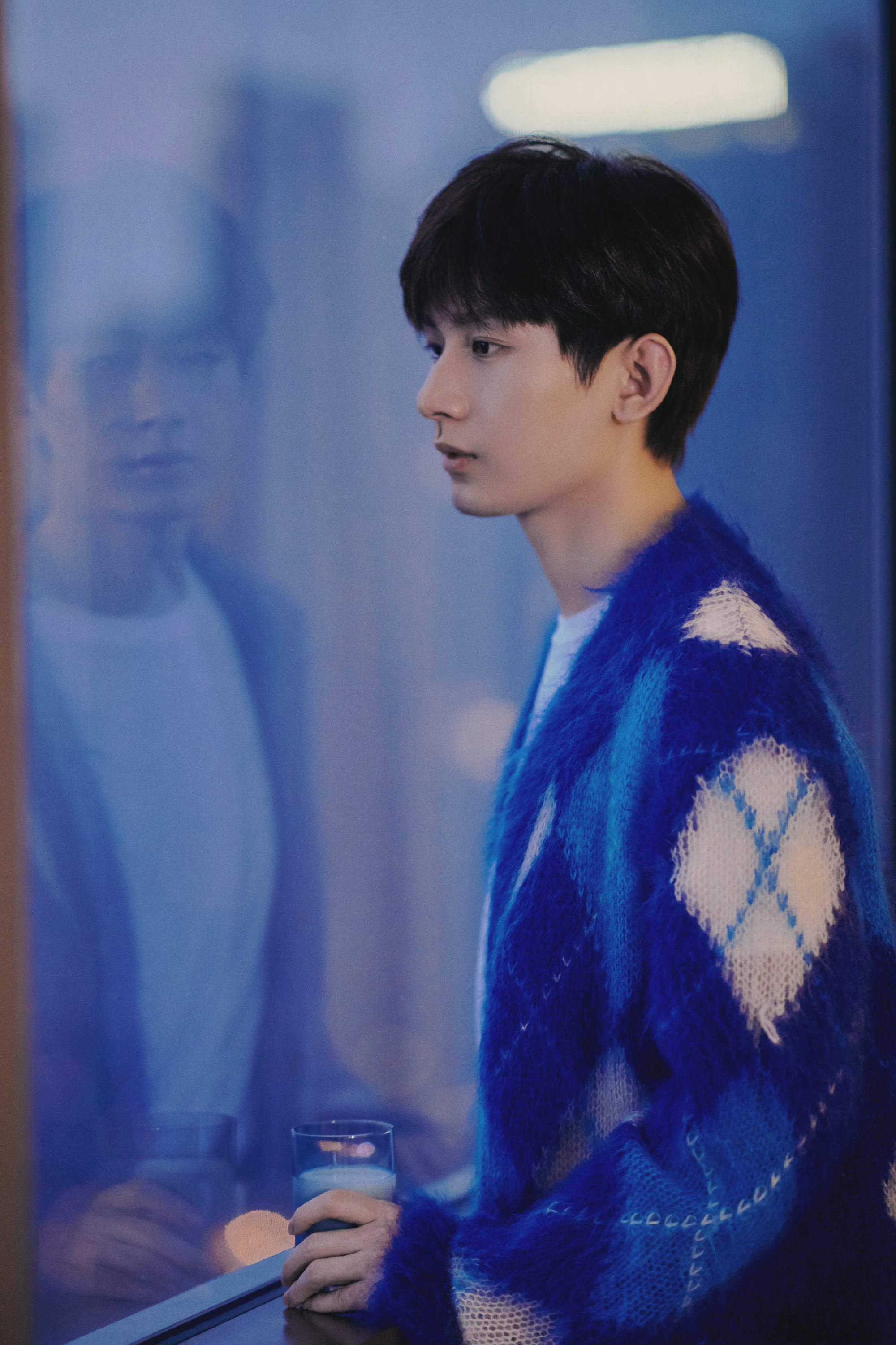 成毅身穿蓝色格纹针织开衫内搭白色t恤,优越的侧颜线条令人羡慕