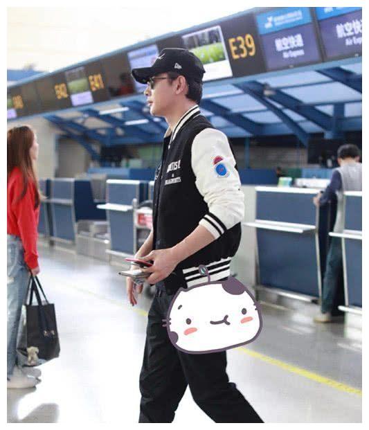 罗晋身穿拼色刺绣棒球夹克下身穿束口休闲裤,脚踩字母印花高帮小白鞋