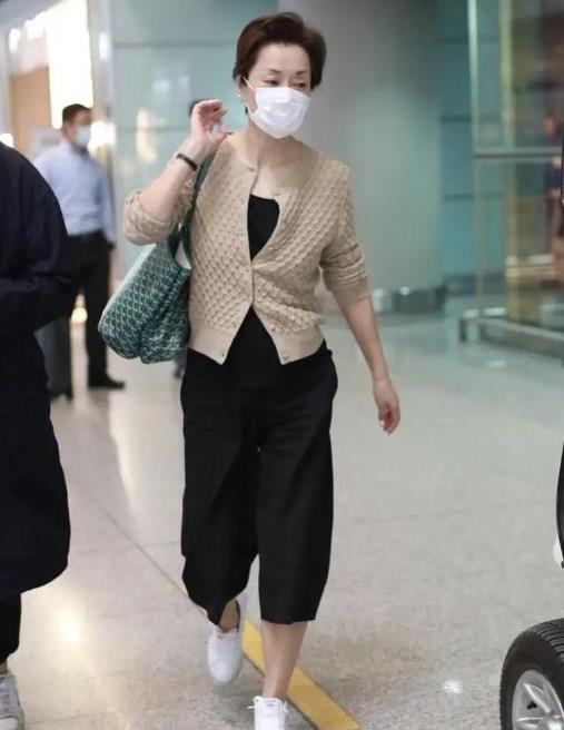 57岁毛阿敏走机场，穿针织开衫搭配七分裤，简约大气追求自然美