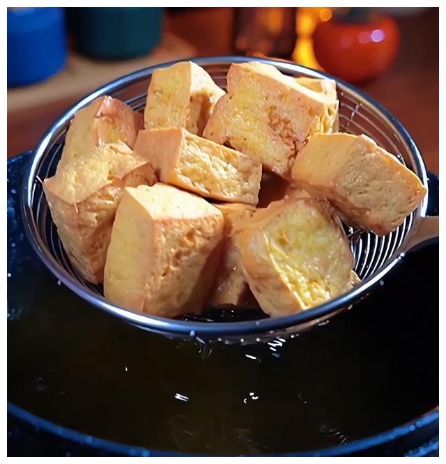 倒入炸豆腐中,不要着急吃,先浸泡一下,最好是用牙签在豆腐上扎点小洞