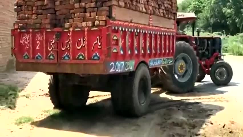 国外农民用拖拉机拉了一车砖,看他怎么卸车的,不怕砖摔坏吗