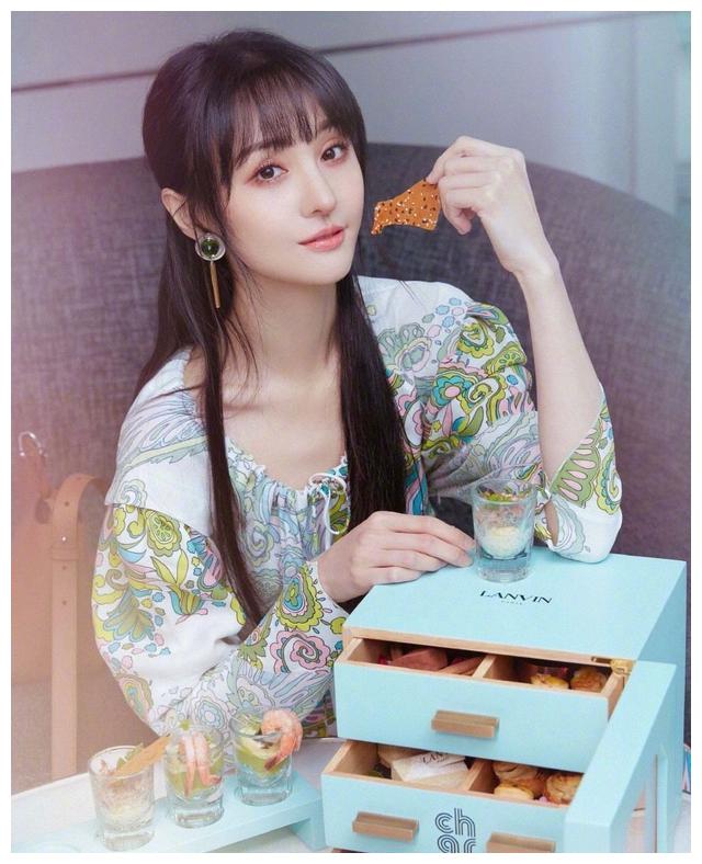 郑爽手捧下午茶出镜,一袭白底印花连衣裙,依旧甜美少女样