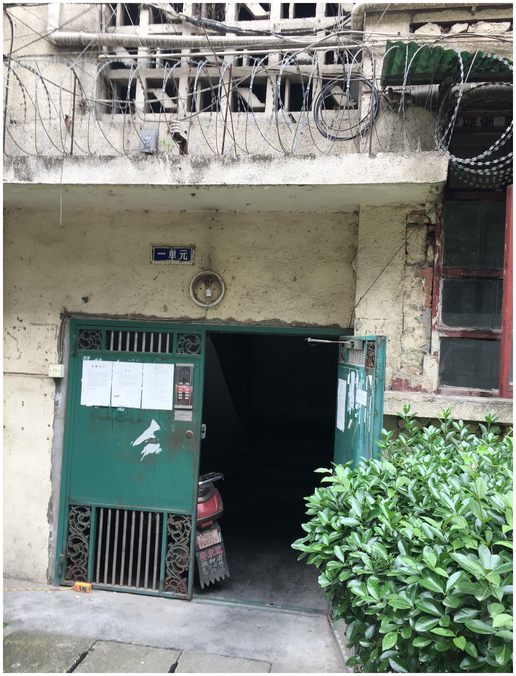 小区单元的大门也是老式的,有点破旧,还打不开关不上,用一个石块顶住.