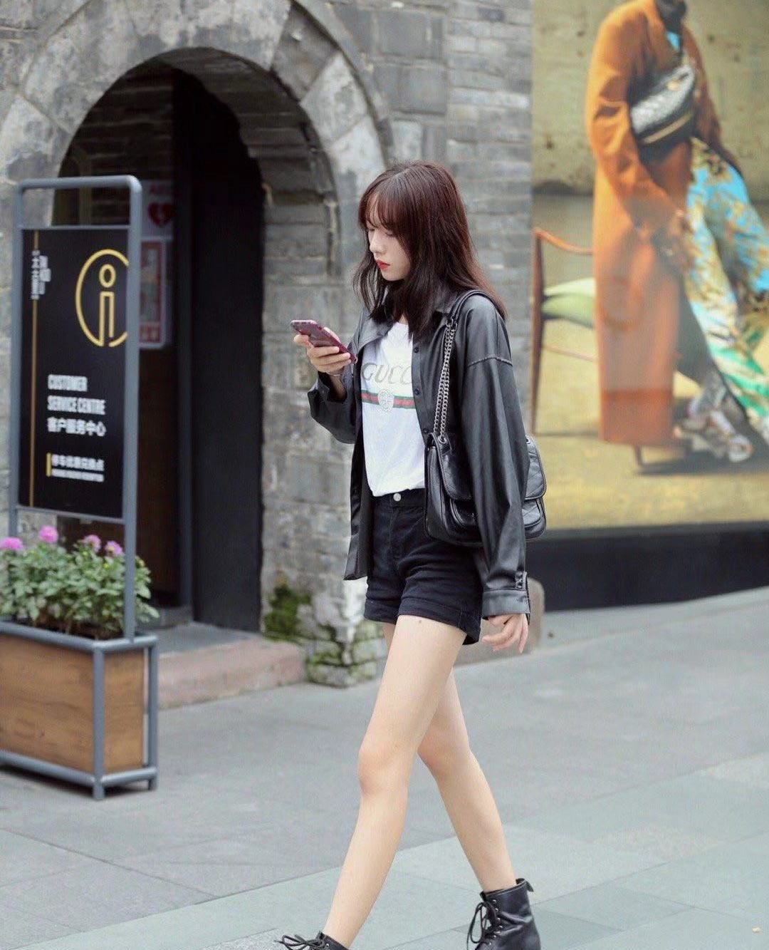 街拍,小姐姐黑色皮衣搭配同色短裤,马丁靴凸显白皙修长双腿