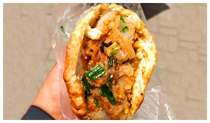 还有一种特色吃法,就是把厚石子馍从中间切开,里面加入炒得很焦的凉粉