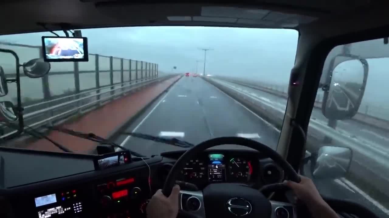 司机一个人开大货车碰到了强劲的大风,一直在不停的修正方向