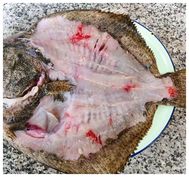 第1步,鲜活的多宝鱼摘去鱼鳃和内脏刮去鱼鳞洗净沥干水份.