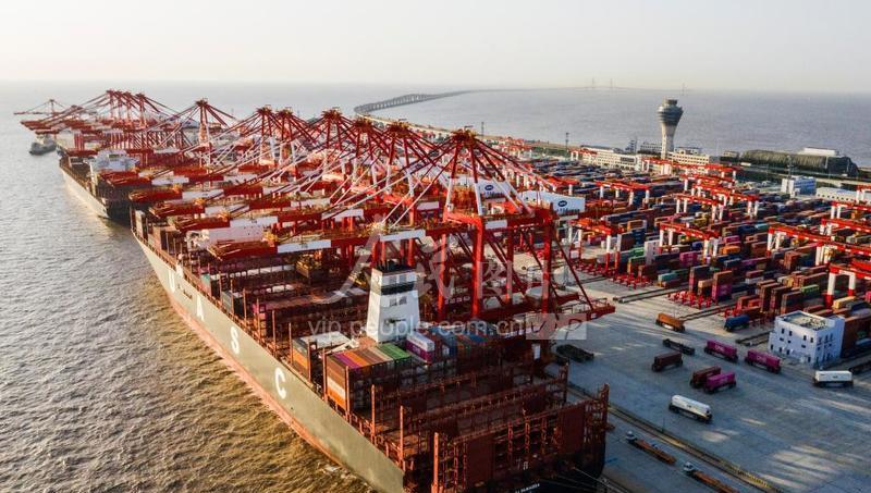 2020年3月20日,上海洋山港自动化码头停泊着多艘超大型集装箱船,卡车