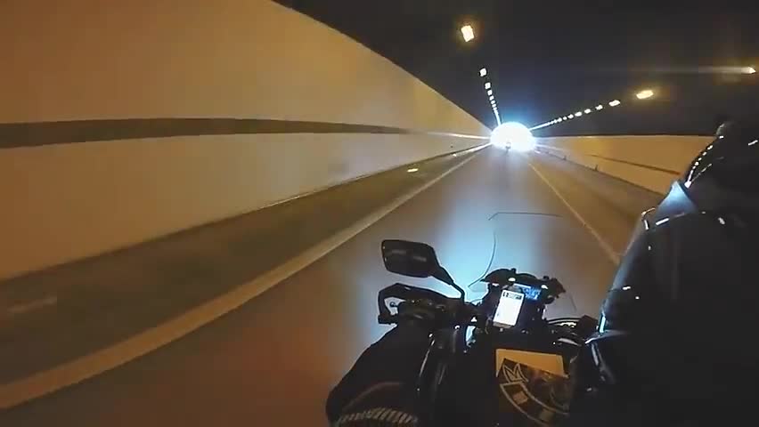 机车手骑摩托车穿过隧道,一路前行