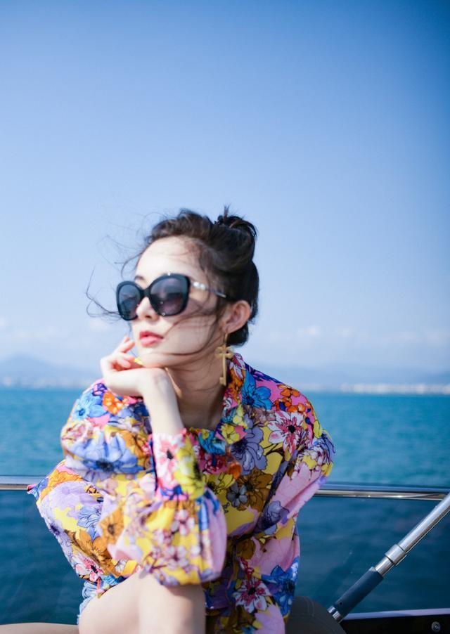 照片中古力娜扎身穿荷叶边印花上衣搭配牛仔短裤,阳光下能够说是美成