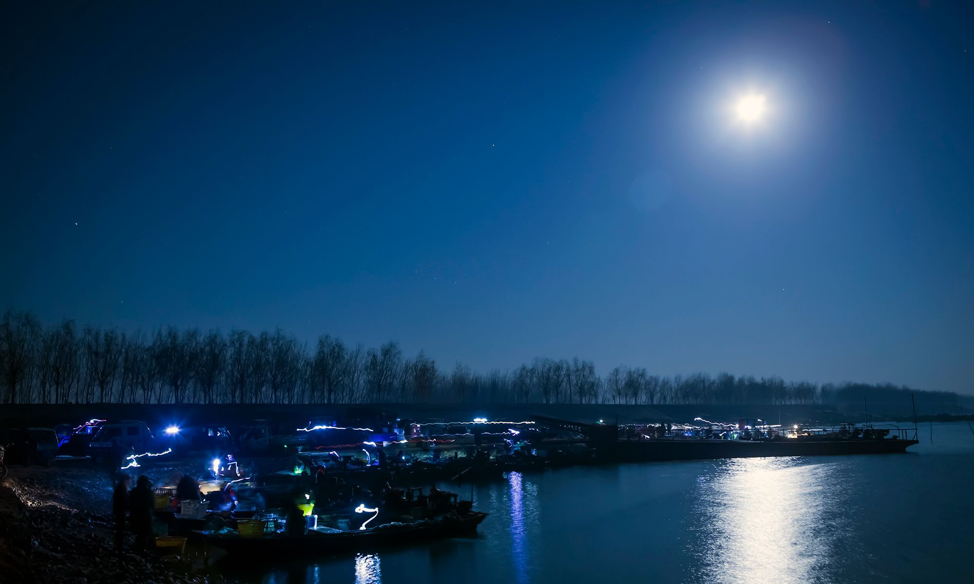 月光下的小渔村,一切是那么静谧,只有码头上还有渔民在忙碌