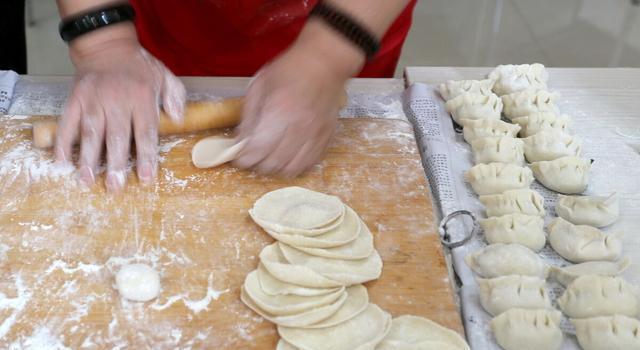 5/ 66,用擀面杖擀成中间厚四周薄的饺子皮,取适量的馅放在皮中间,捏合