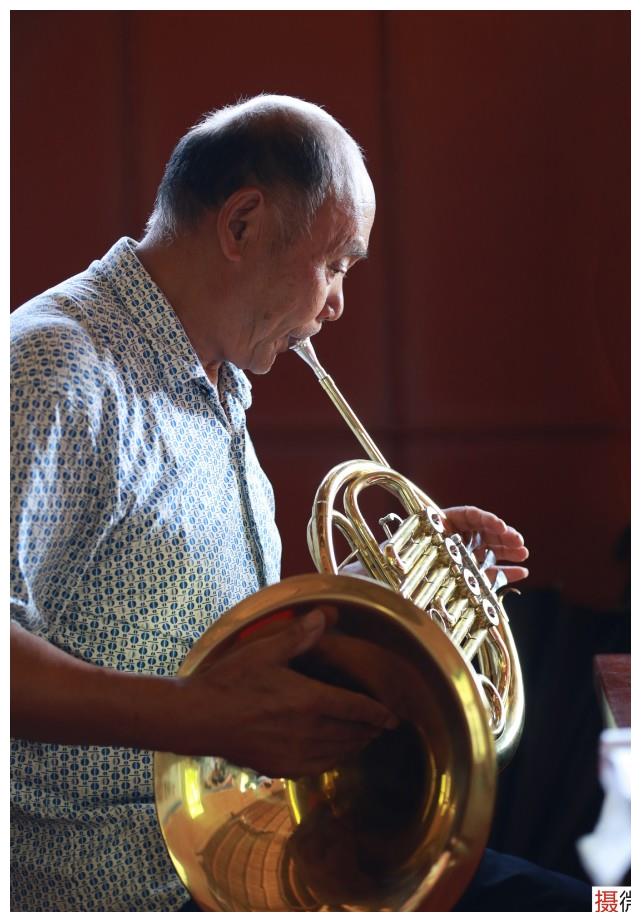 71岁的李天明大爷正在吹圆号,他是乐团的积极分子,每次练习和演出都
